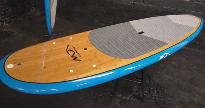Wooden stand-up paddleboard on dock ready for coastal paddling