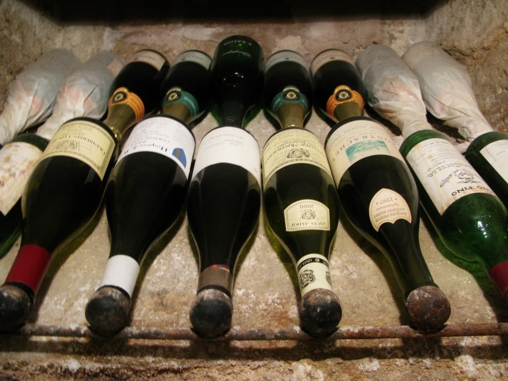 Bottles of aged Spanish wine in rustic cellar rack, Valencia