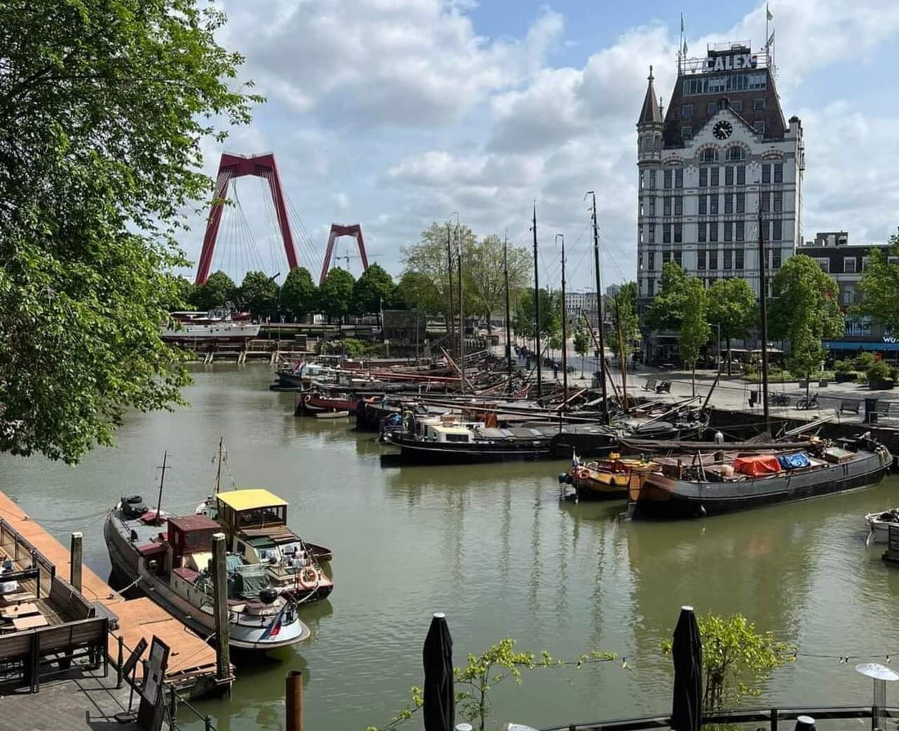 Boat-lined canal with church tower in Delft old town waterfront