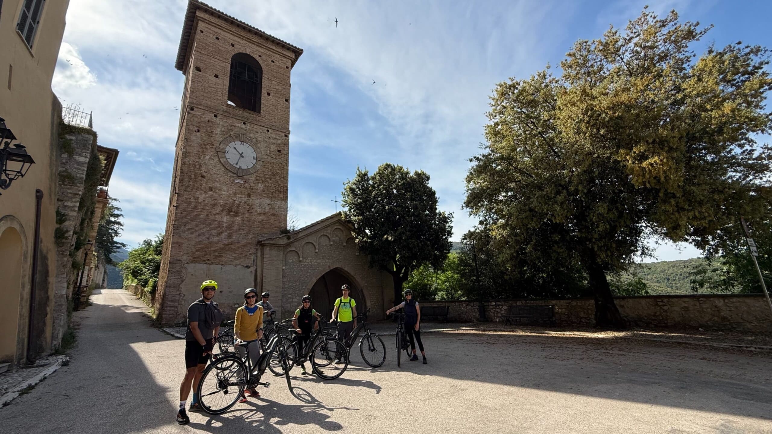 Group cyclists gathering by historic village church square