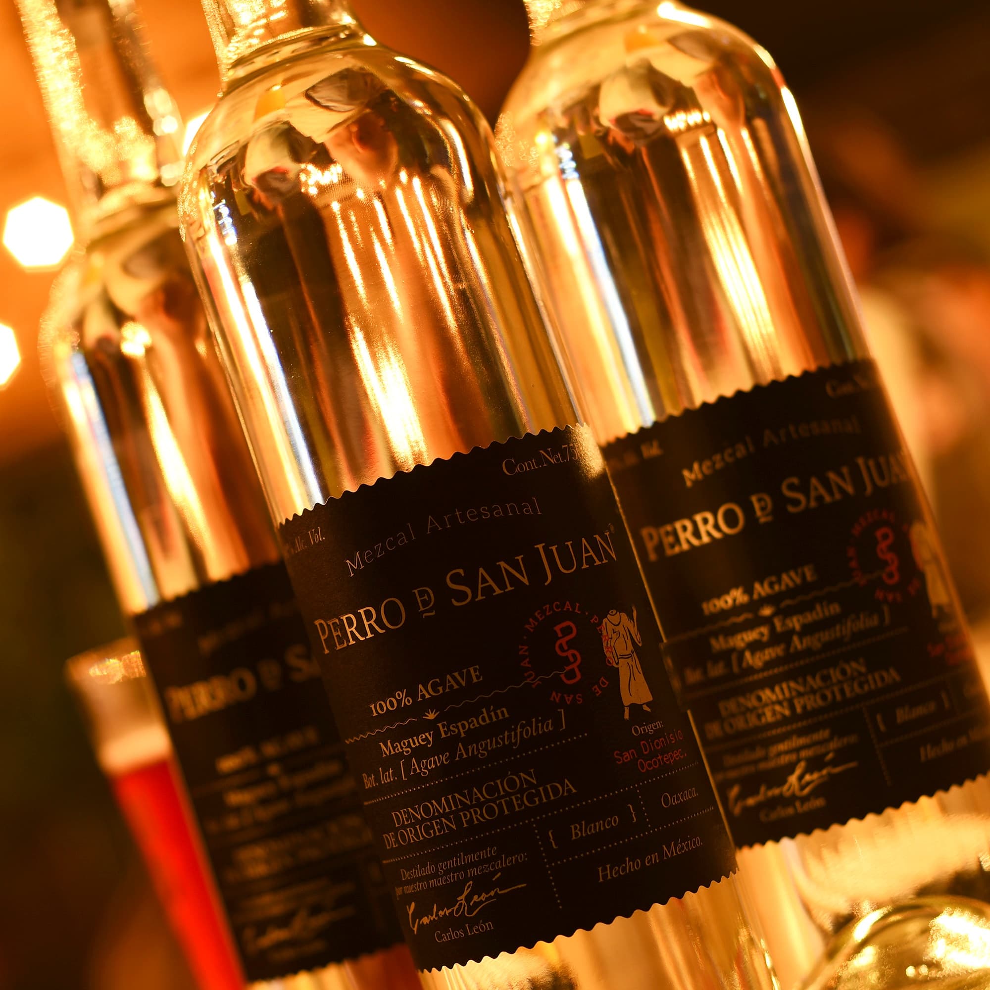 Close-up tequila bottles with warm lighting in bar setting