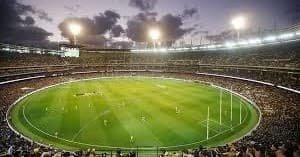 Panoramic view of lit sports stadium hosting large outdoor match