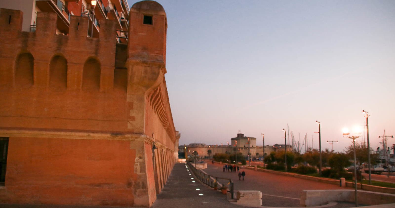 Sunset coastal fortress wall and promenade overlooking harbor