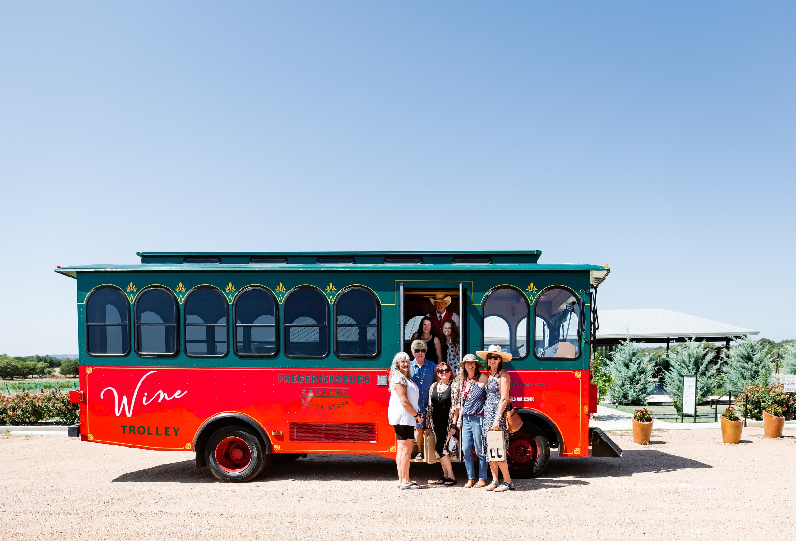 Colorful trolley parked at vineyard entrance with guests