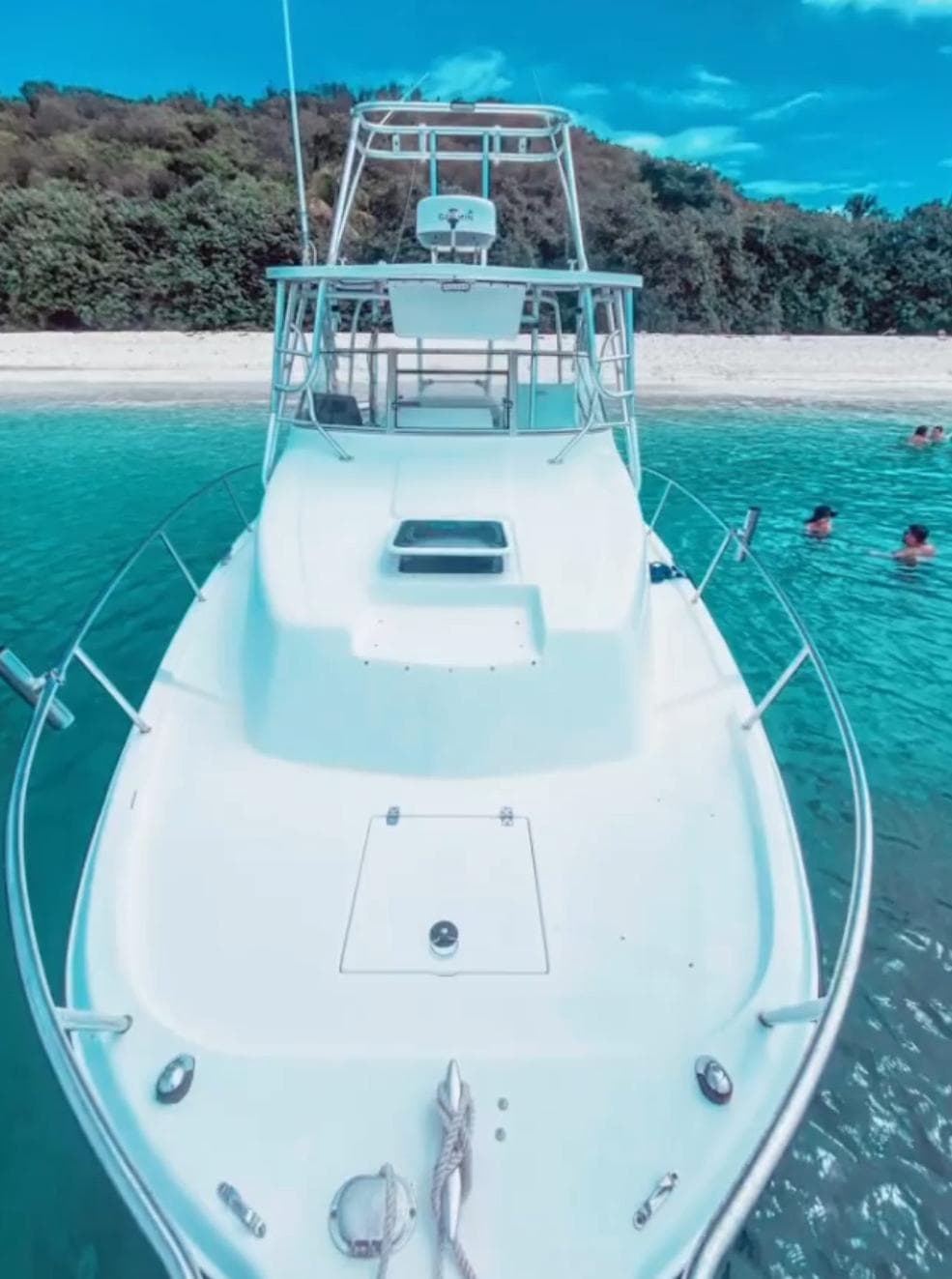 White motorboat moored in turquoise Caribbean coastal water