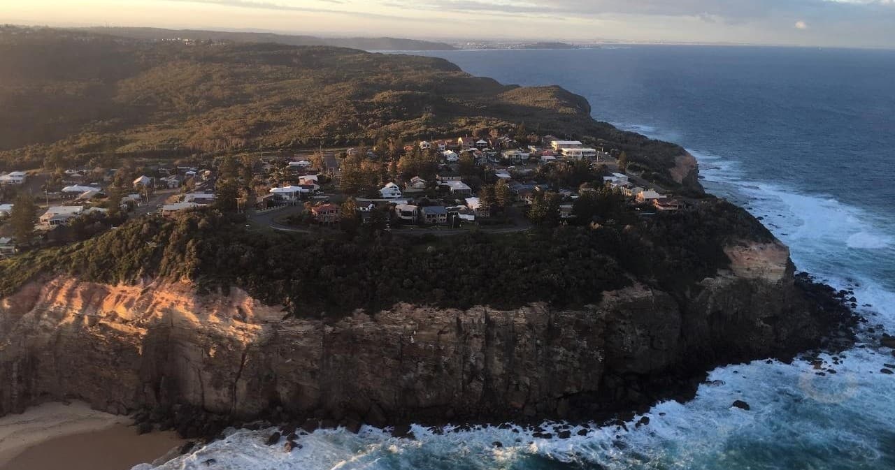 Clifftop coastal town and rugged shoreline from aerial viewpoint