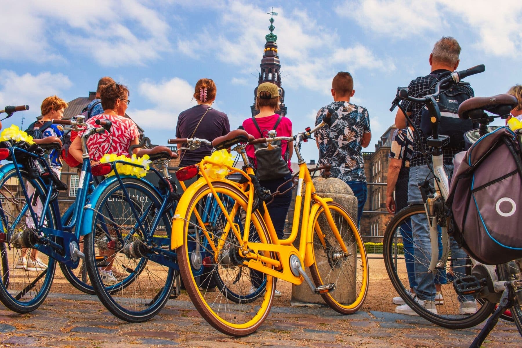 Yellow bikes lined up with Copenhagen skyline and church tower