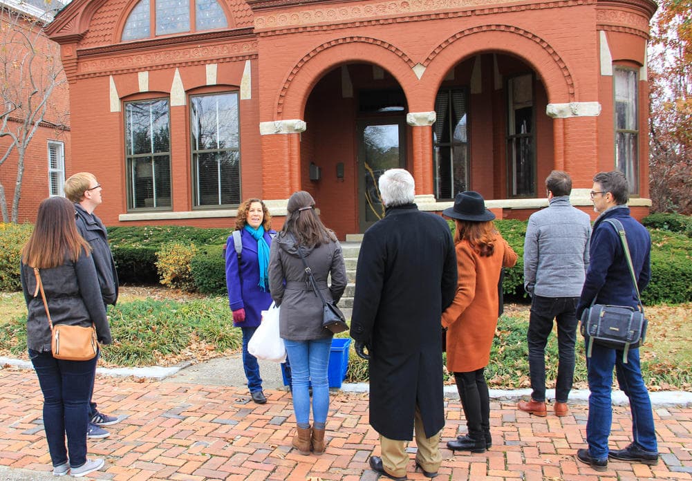 Walking tour group outside red brick historic Nashville mansion