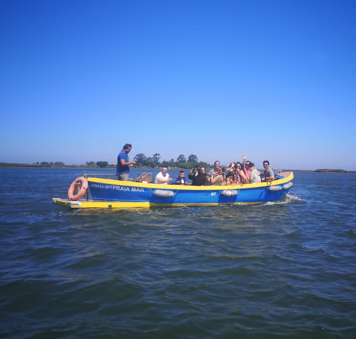 Tourists in inflatable yellow boat on scenic coastal waters