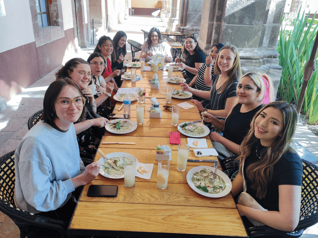 Outdoor communal lunch on courtyard table with smiling diners