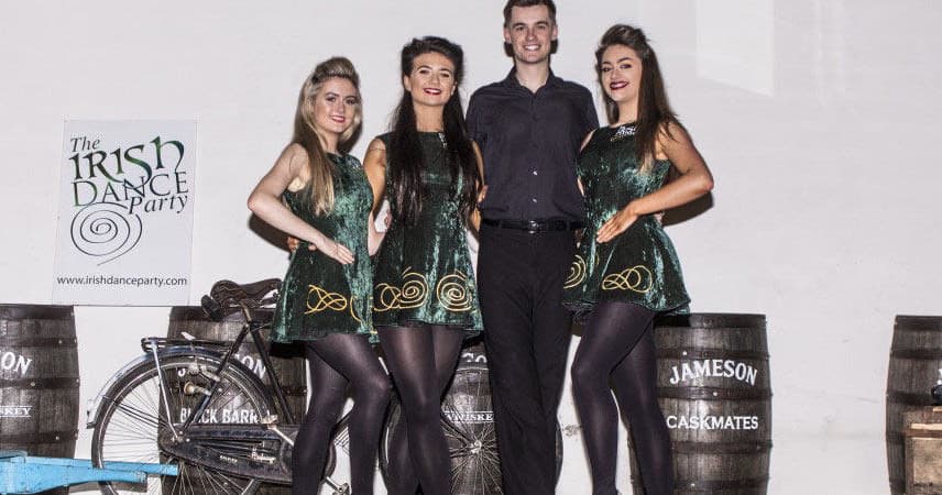 Irish step dancers posed on stage indoors at a pub event