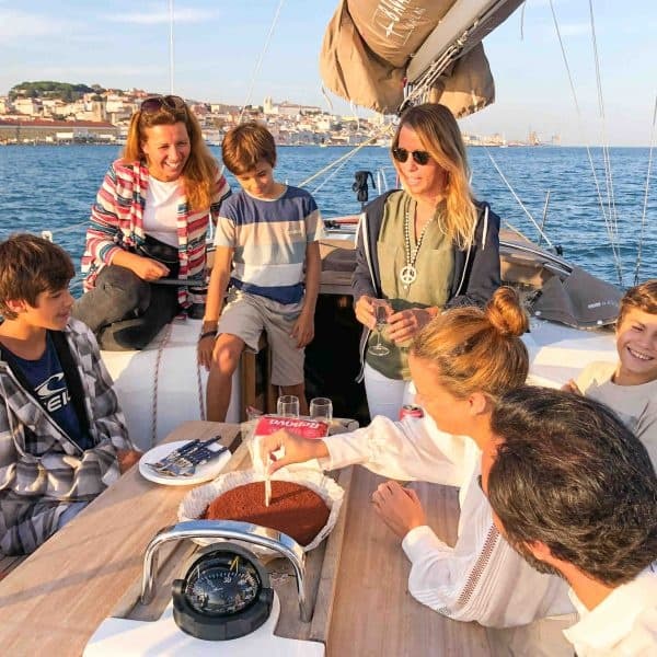 Family and friends socializing on sailboat deck during daytime cruise