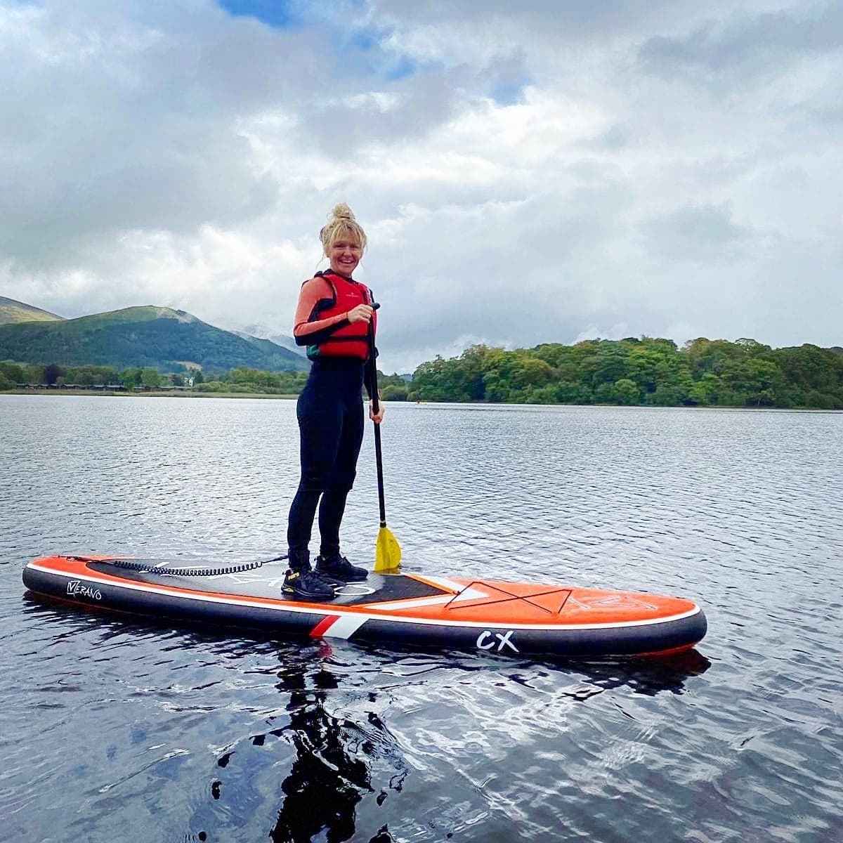 Kayak bow cutting through still water toward distant hills
