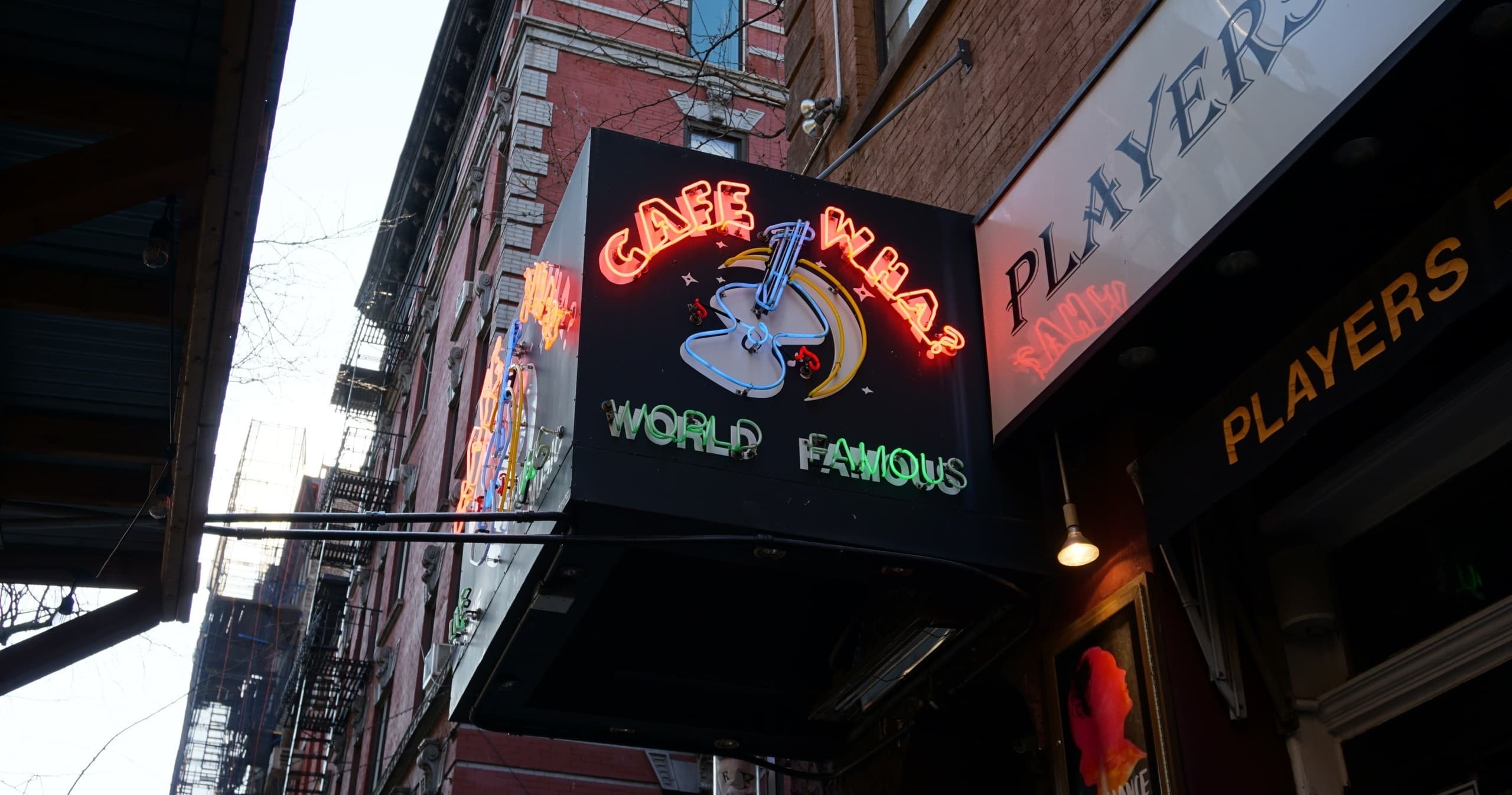 Neon club sign marking historic Greenwich Village comedy venue exterior