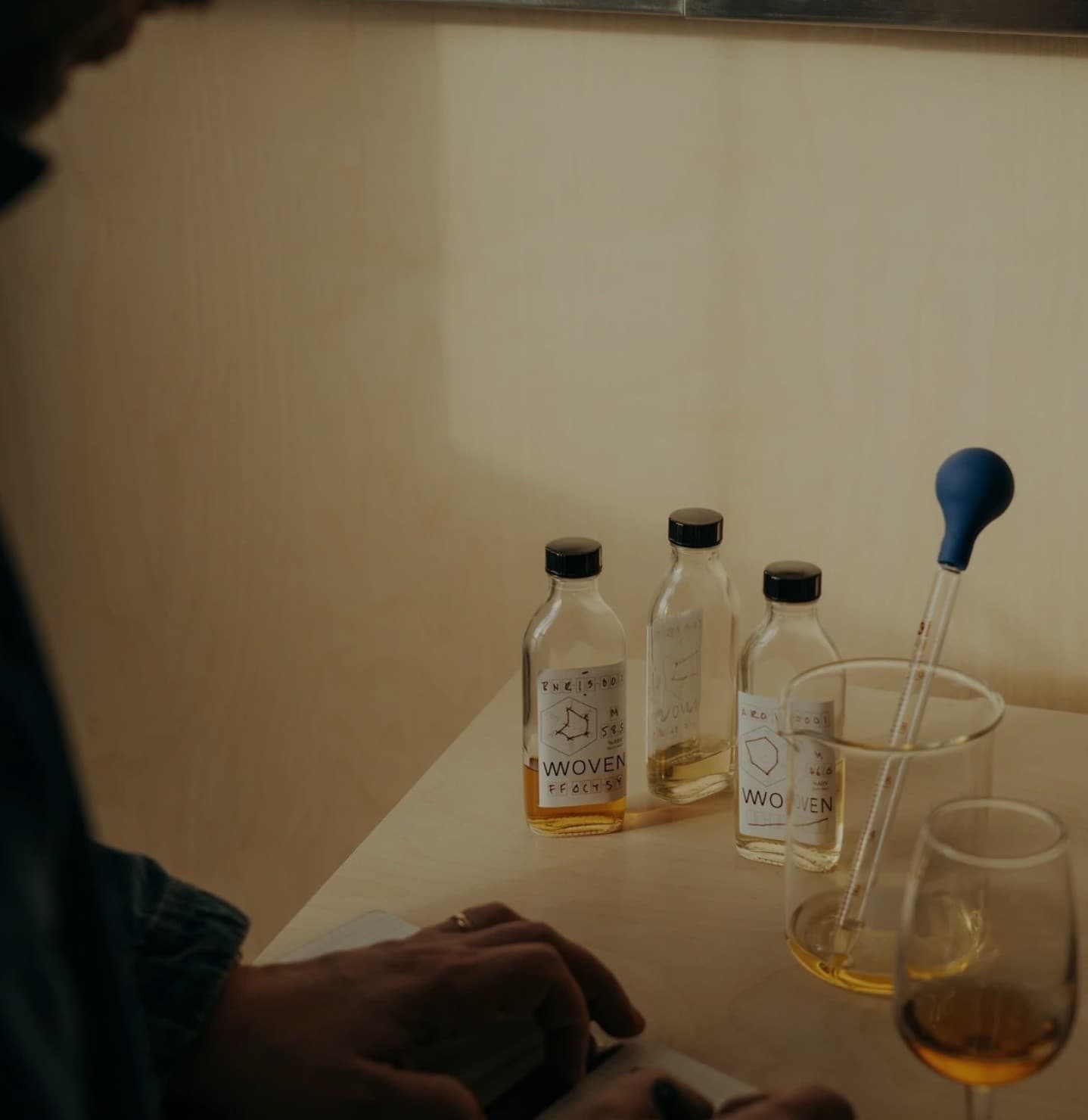 Close-up whisky sample bottles and pipette on tasting bench
