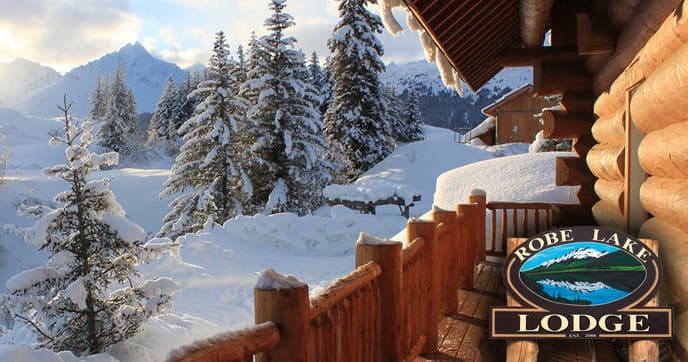 Snow-covered mountain chalet balcony overlooking pine-filled valley