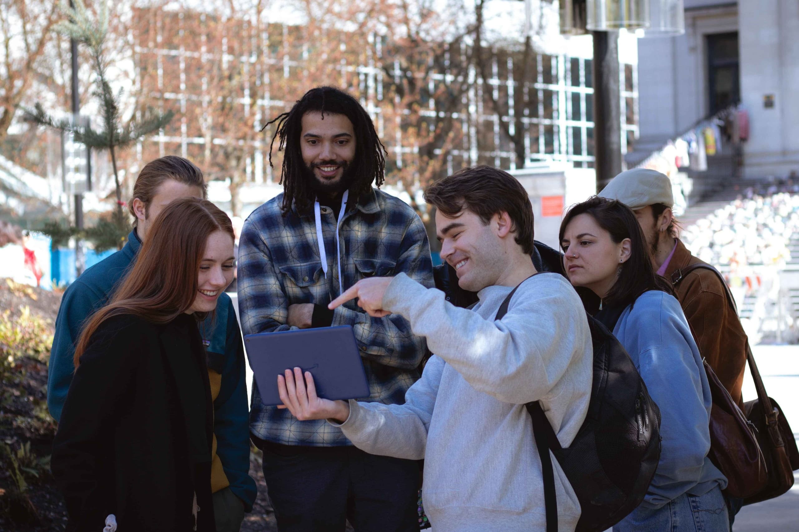 Group of travelers checking a tablet map in an urban park