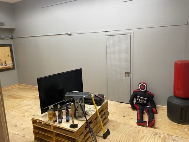 Indoor axe-throwing lane with wooden pallets and targets