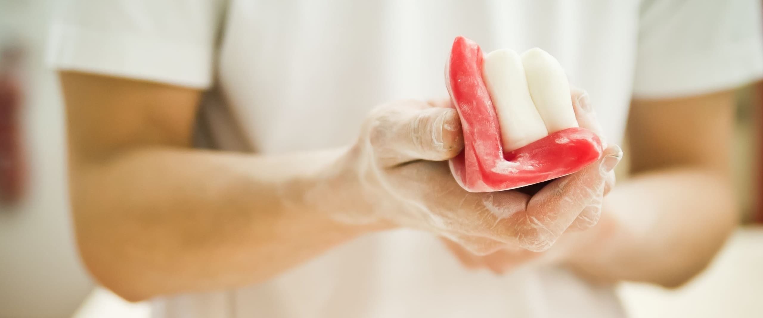 Chef shaping red and white candy by hand in candy kitchen