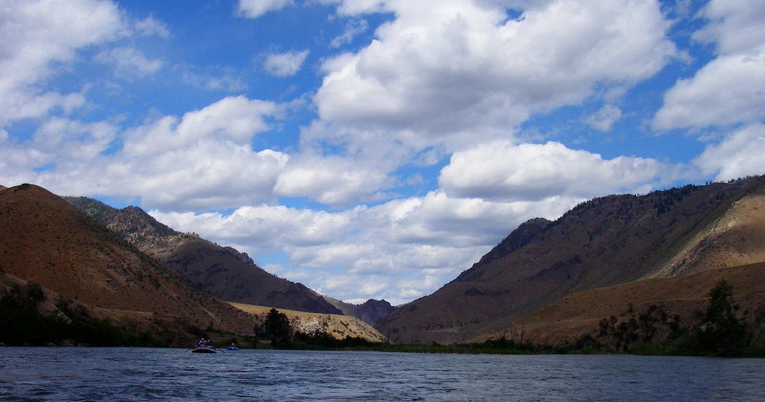 Mountain lake with kayaker-ready shoreline under blue skies