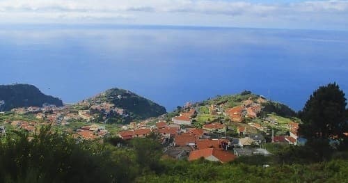 Aerial view of terraced hillside village and green valleys