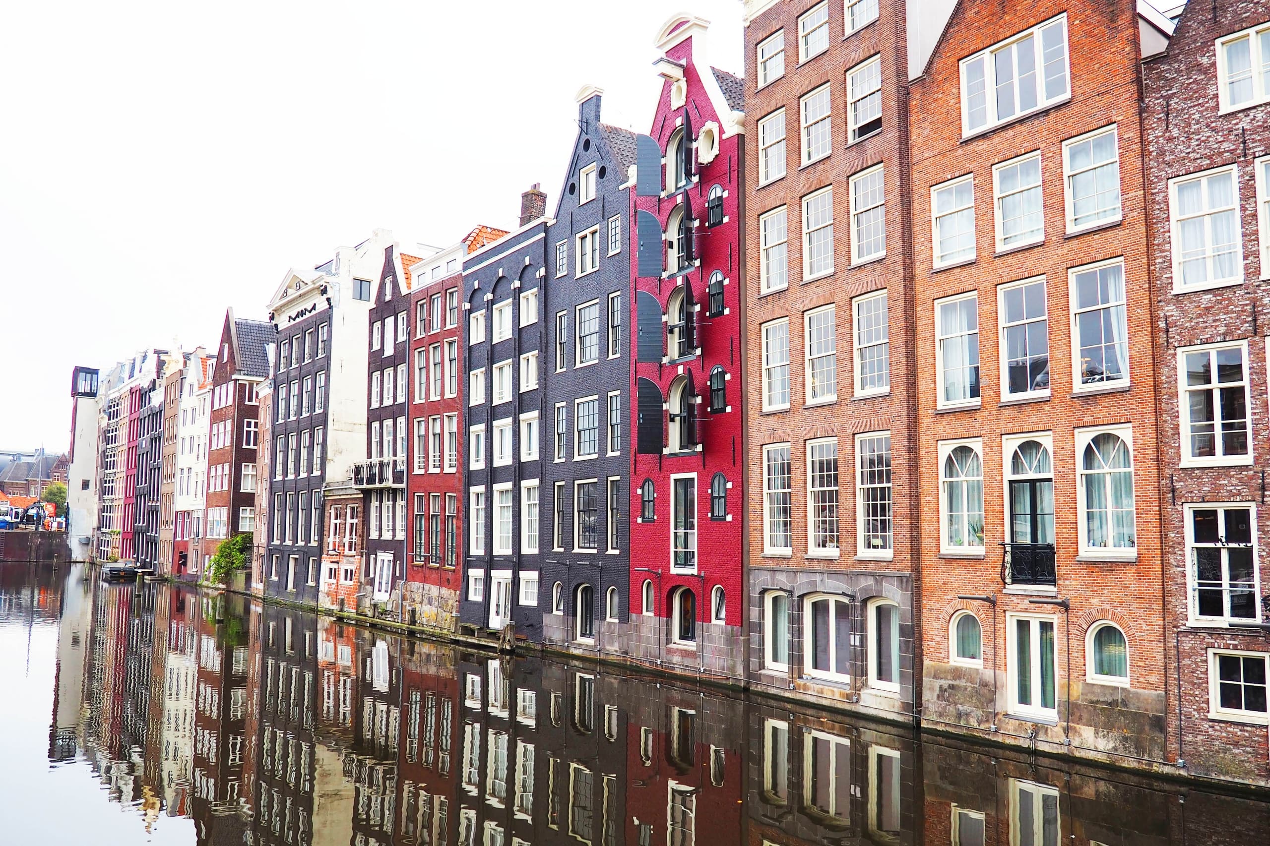 Colorful Amsterdam canal houses reflecting in water, scenic canal