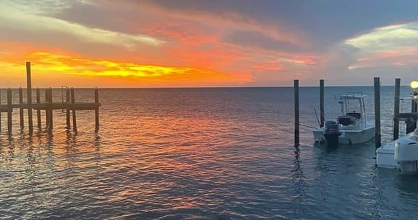 Sunset over marina docks and calm bay waters, coastal boating