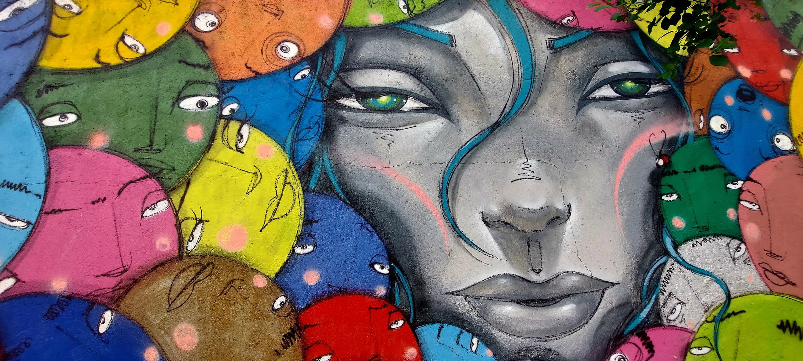 Colorful street art collage with stylized face on Lisbon wall tour
