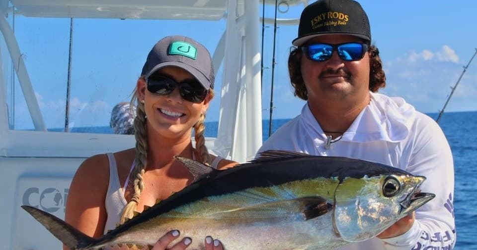 Anglers holding yellowfin tuna on offshore sportfishing boat