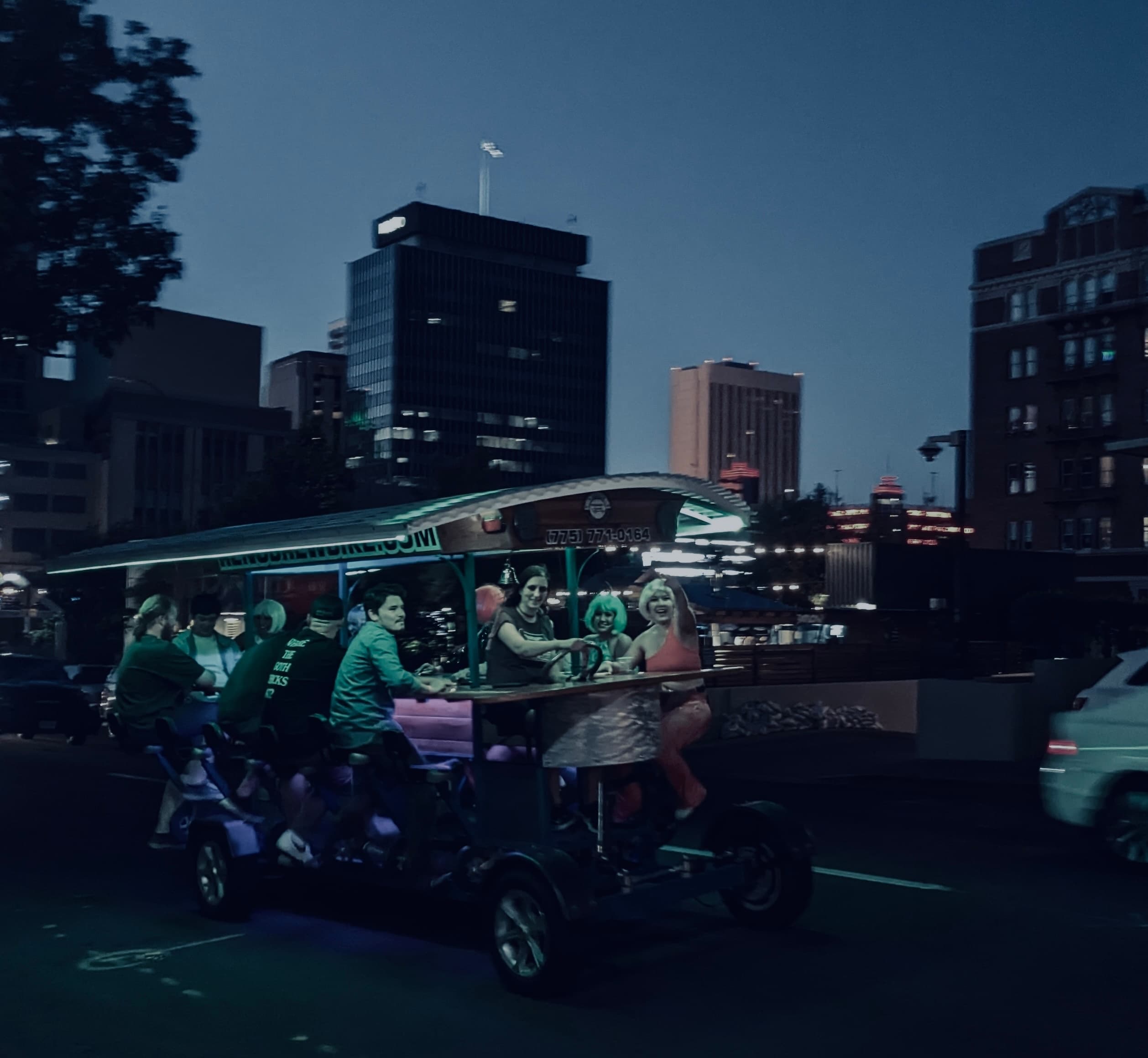 Nighttime pedal pub tour on Reno city streets with skyline