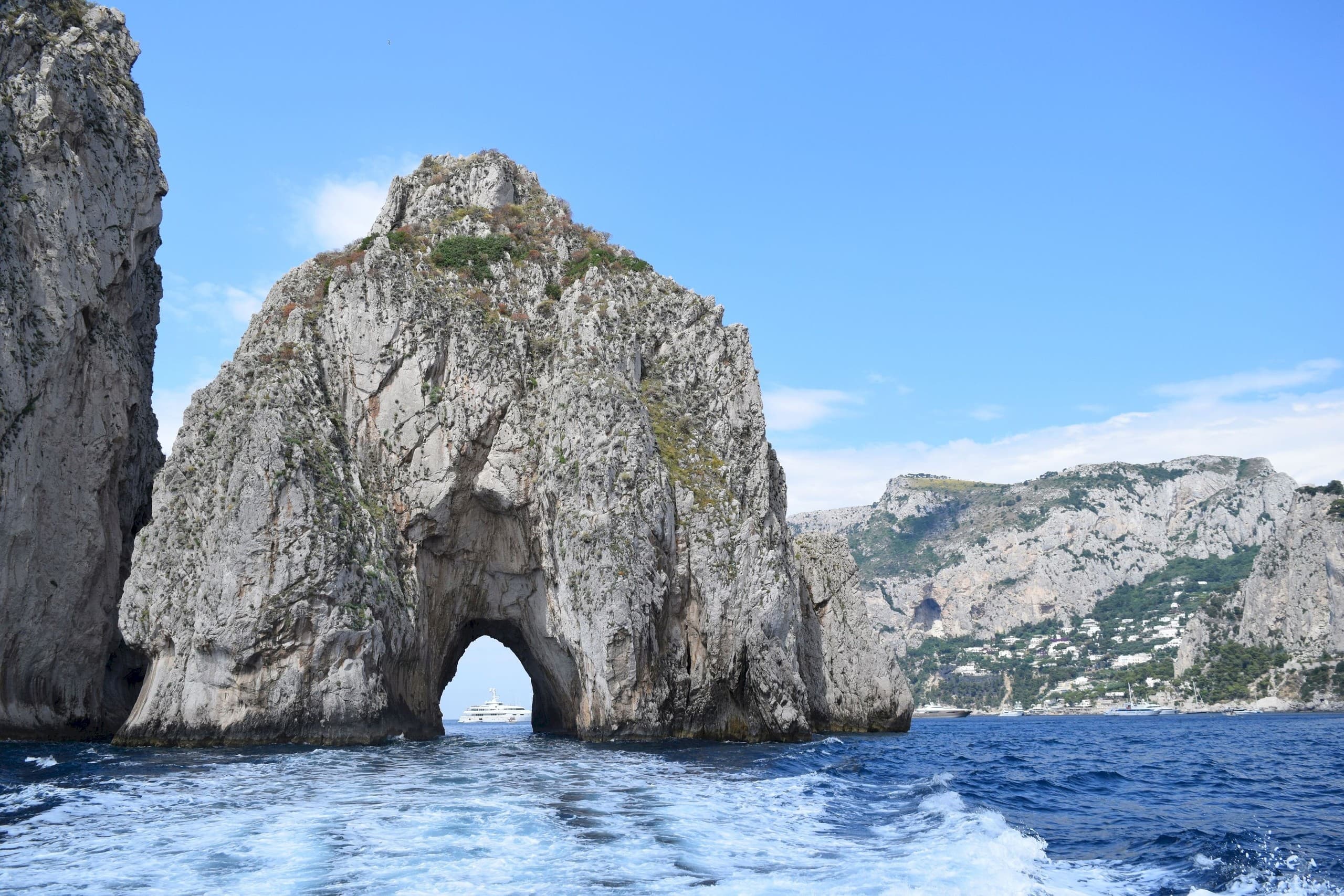 Sea arch rock formation off coast with waves, scenic vista