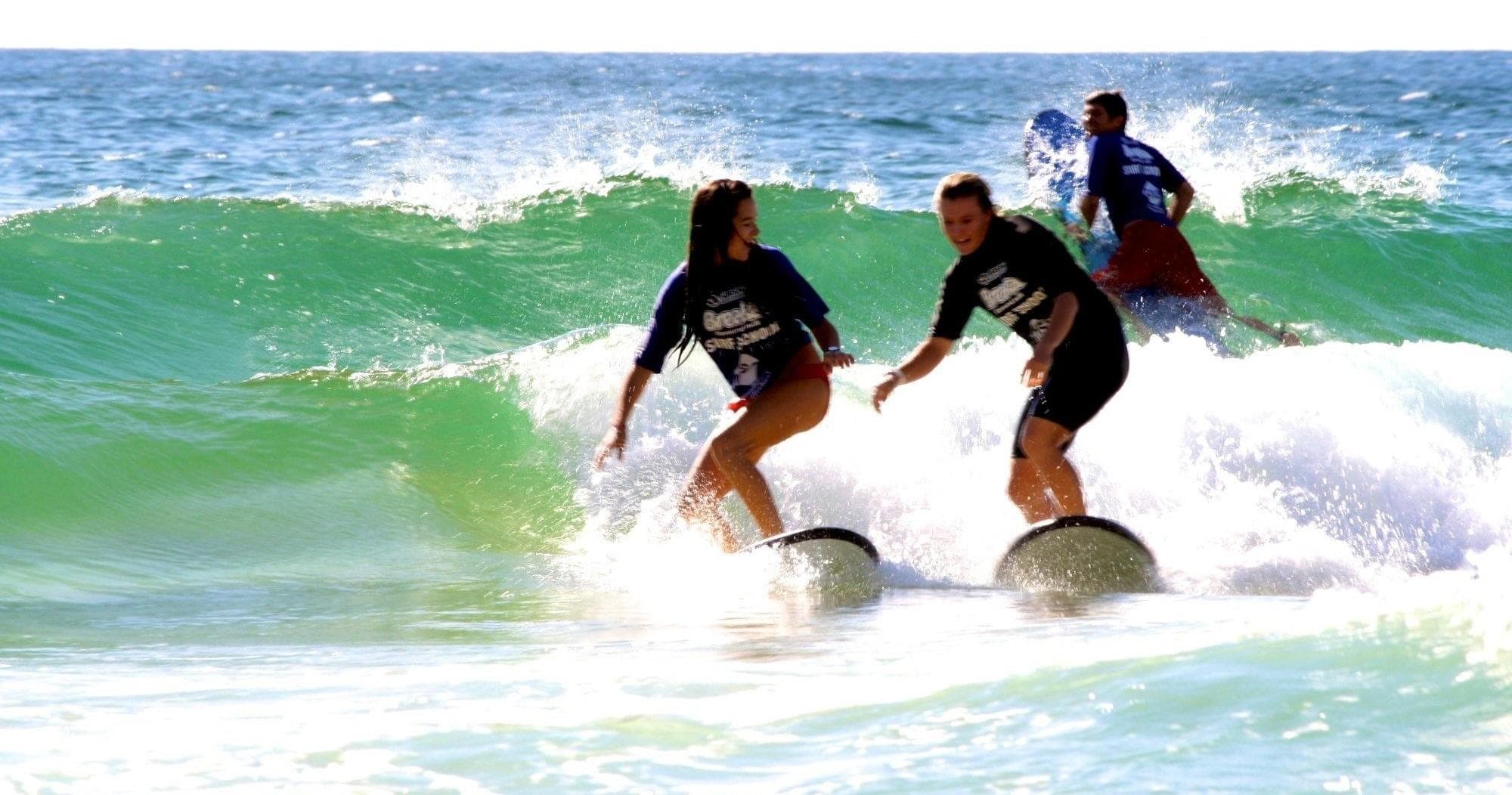 Two surfers riding a green wave together at Broadbeach