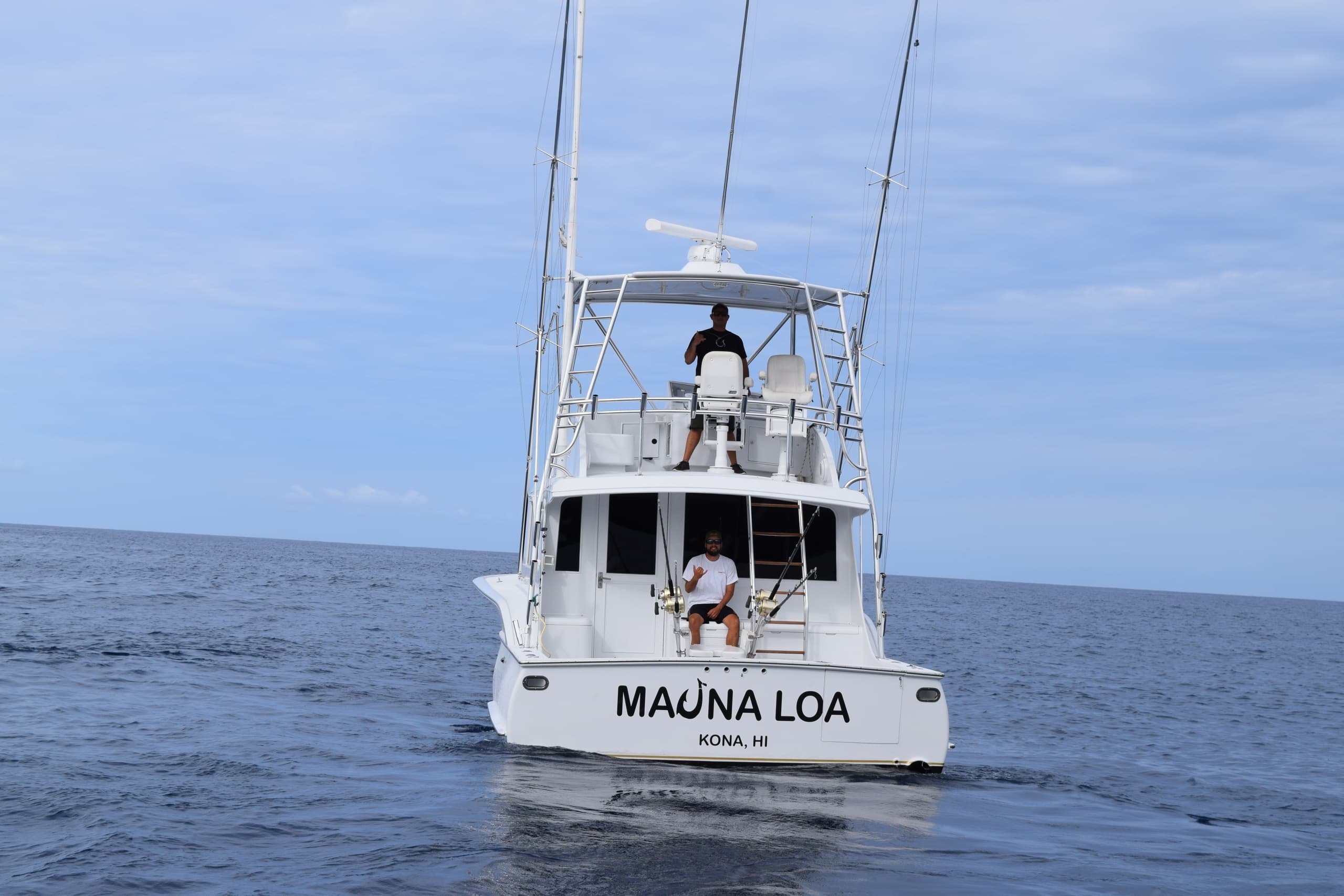 Fishing charter stern view named Mauna Loa on calm ocean