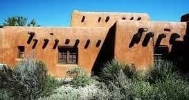 Visitors exploring adobe pueblo-style architecture on Santa Fe walking tour