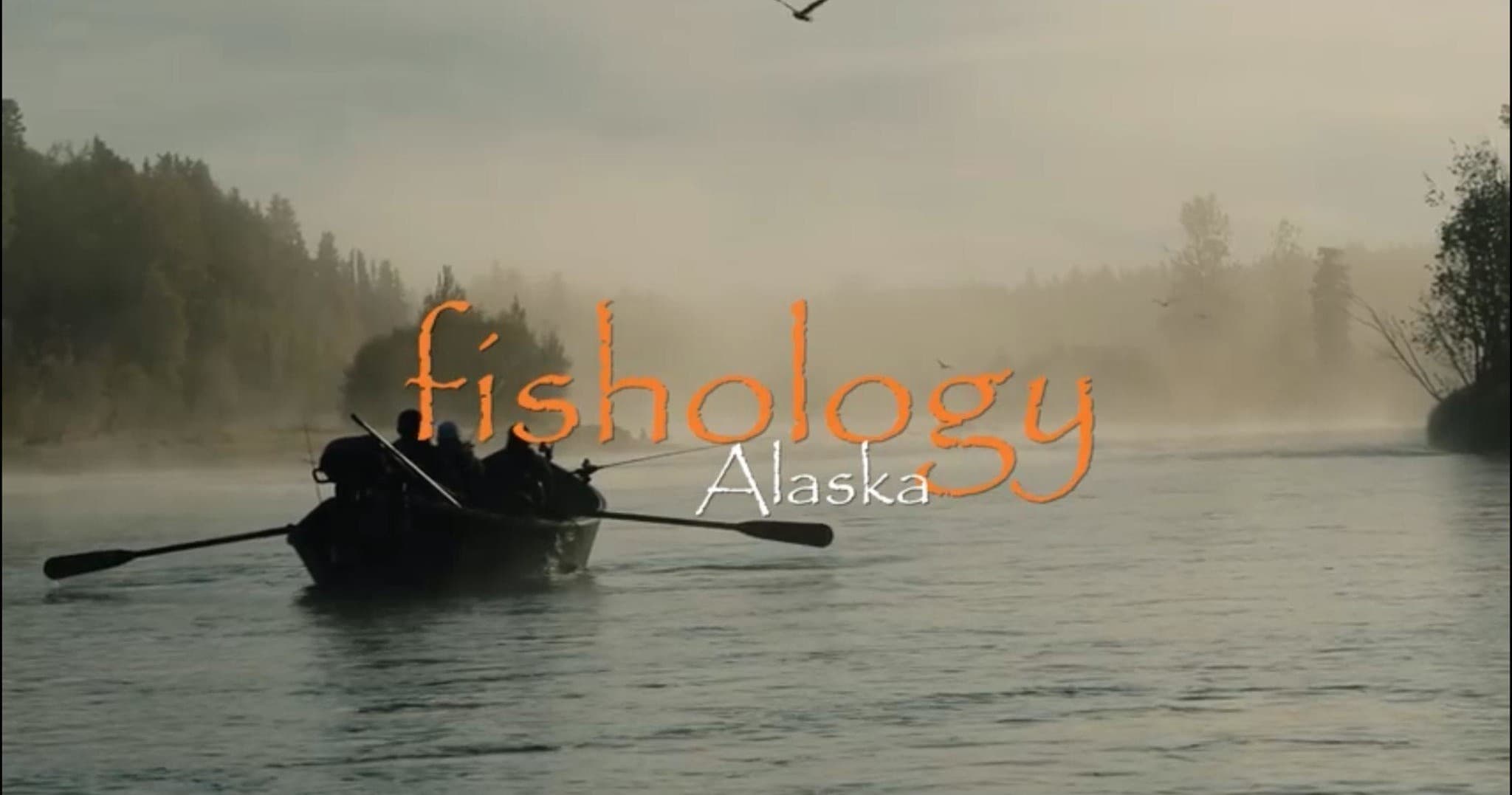Fisherman rowing misty river at dawn in Alaska