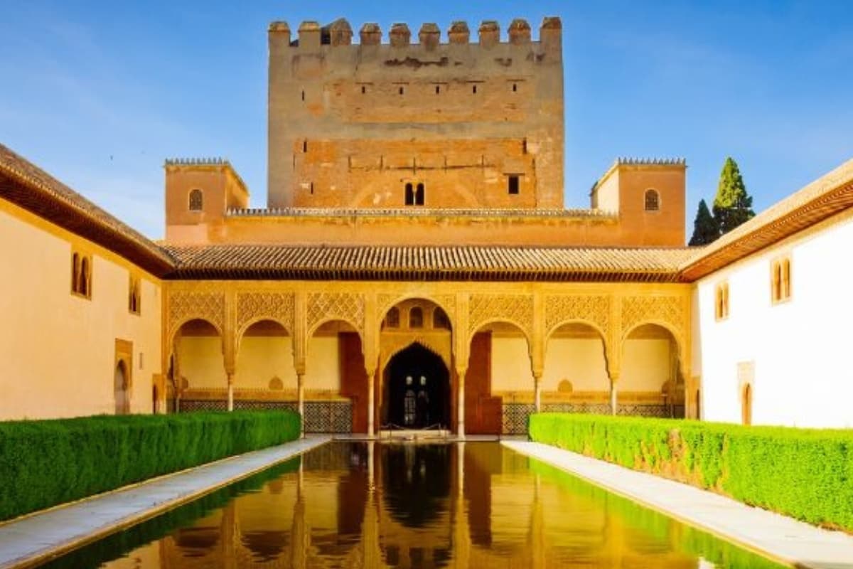 Wide sunny view of Alhambra palace gardens and mountain backdrop