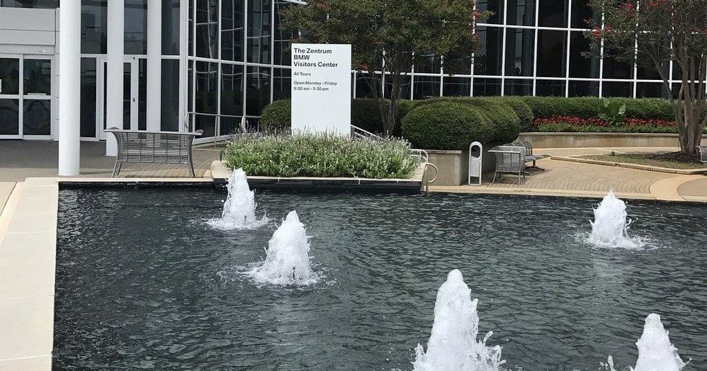 Outdoor reflecting fountain plaza outside BMW facility with water jets