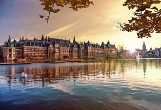 Historic waterfront architecture reflected in Dutch canal at sunset