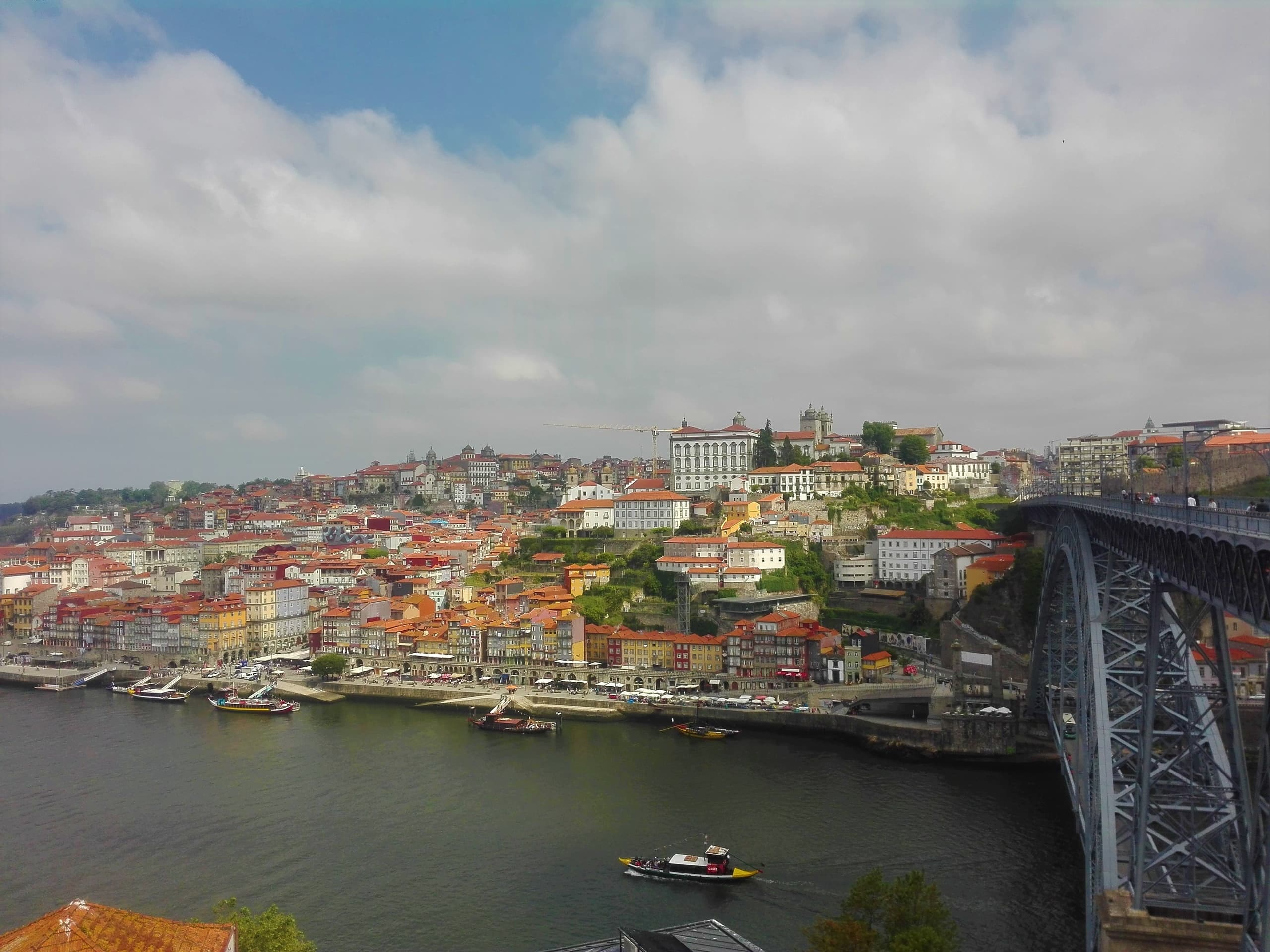 Panoramic riverside cityscape with historic bridge and boats