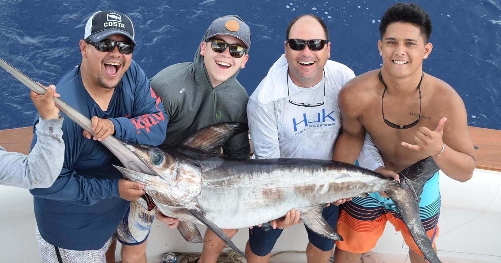 Group of anglers posing with swordfish catch on offshore Miami charter