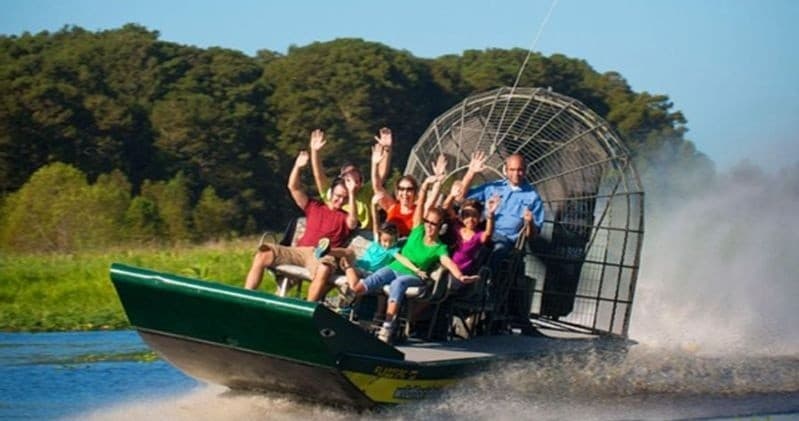 High-speed airboat ride in Florida wetlands with excited passengers
