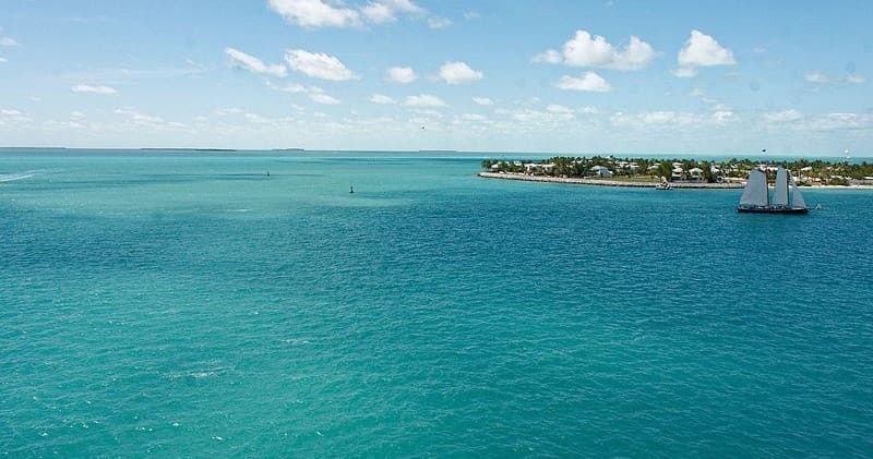 Aerial turquoise ocean with distant island, scenic coastal vista