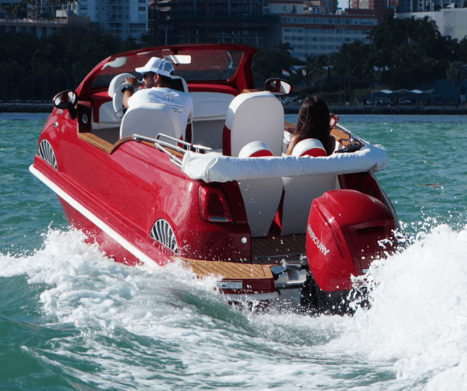 Red speedboat powering through wake in coastal waters