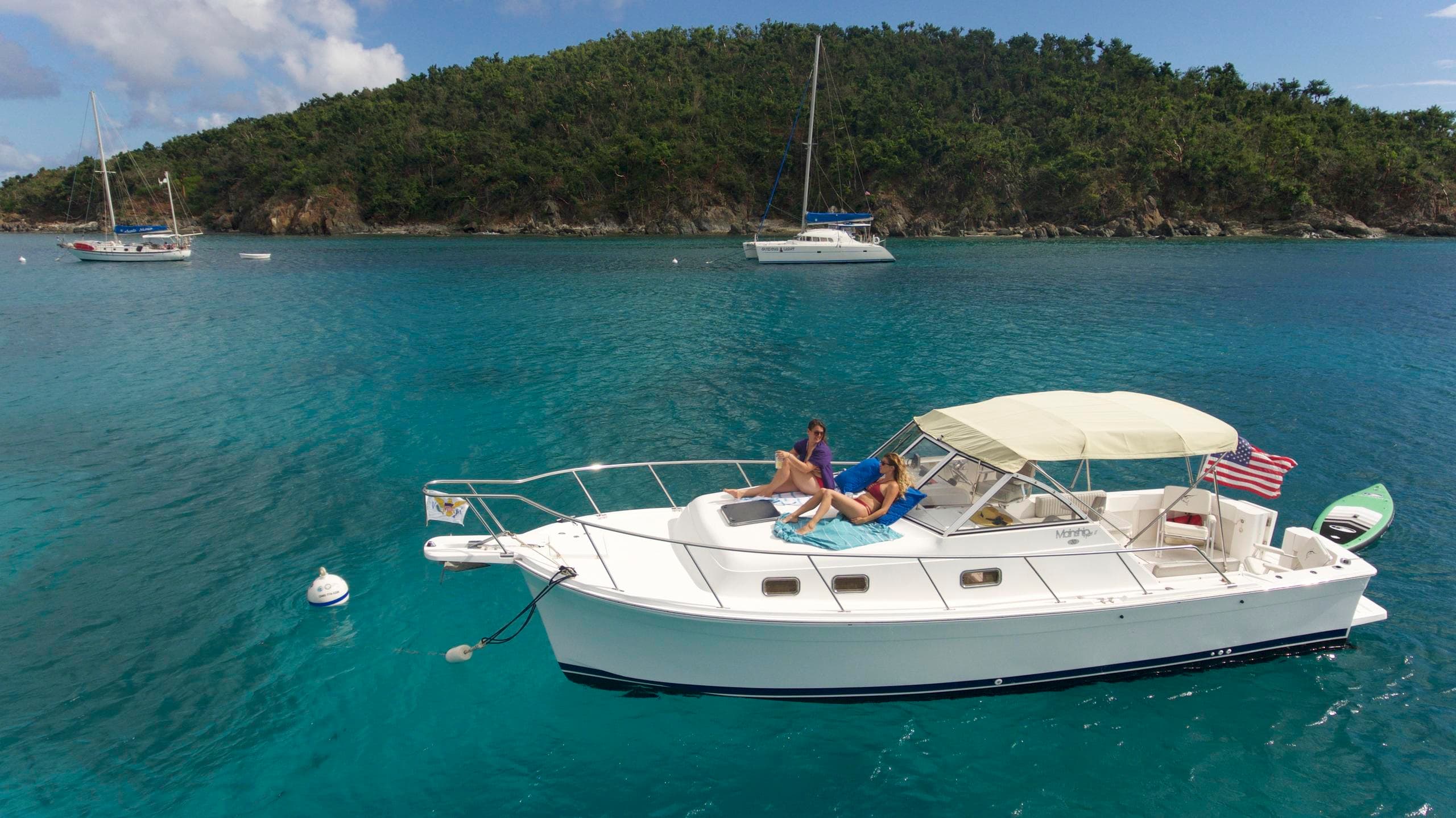 Luxury motor yacht cruising near tropical island shoreline