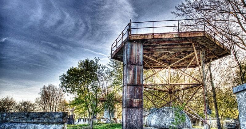 Rustic watchtower and paintball obstacles in scenic park field