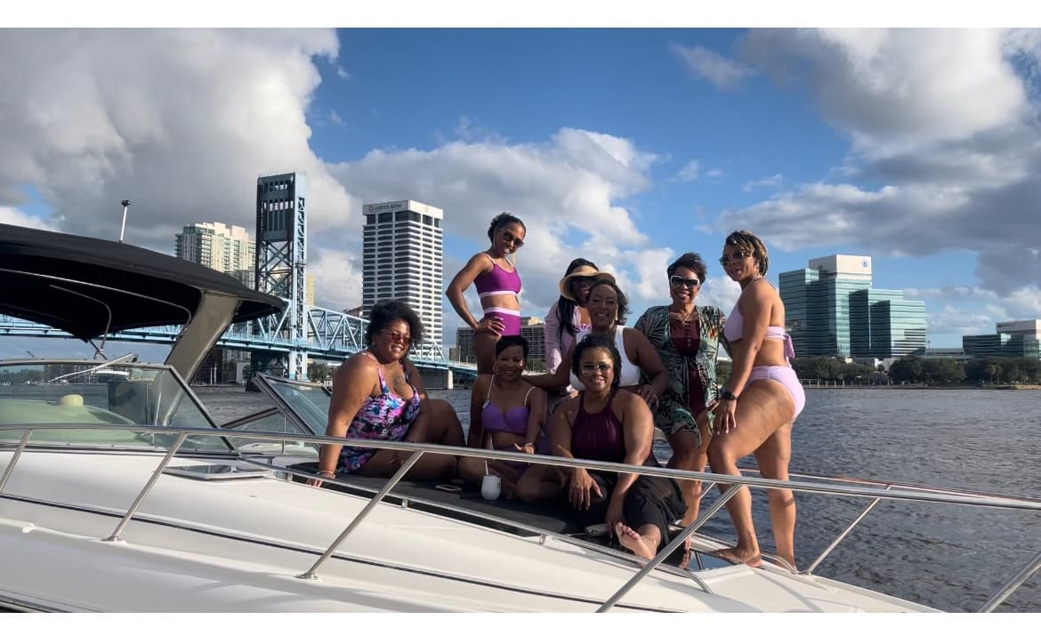Group relaxing on yacht deck with city skyline waterfront