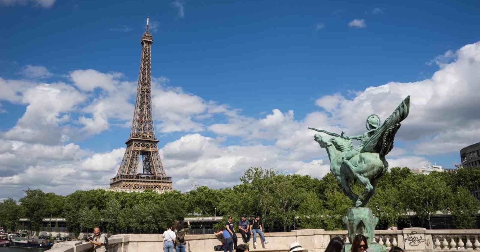 Eiffel Tower with foreground sculpture under clear blue Paris sky