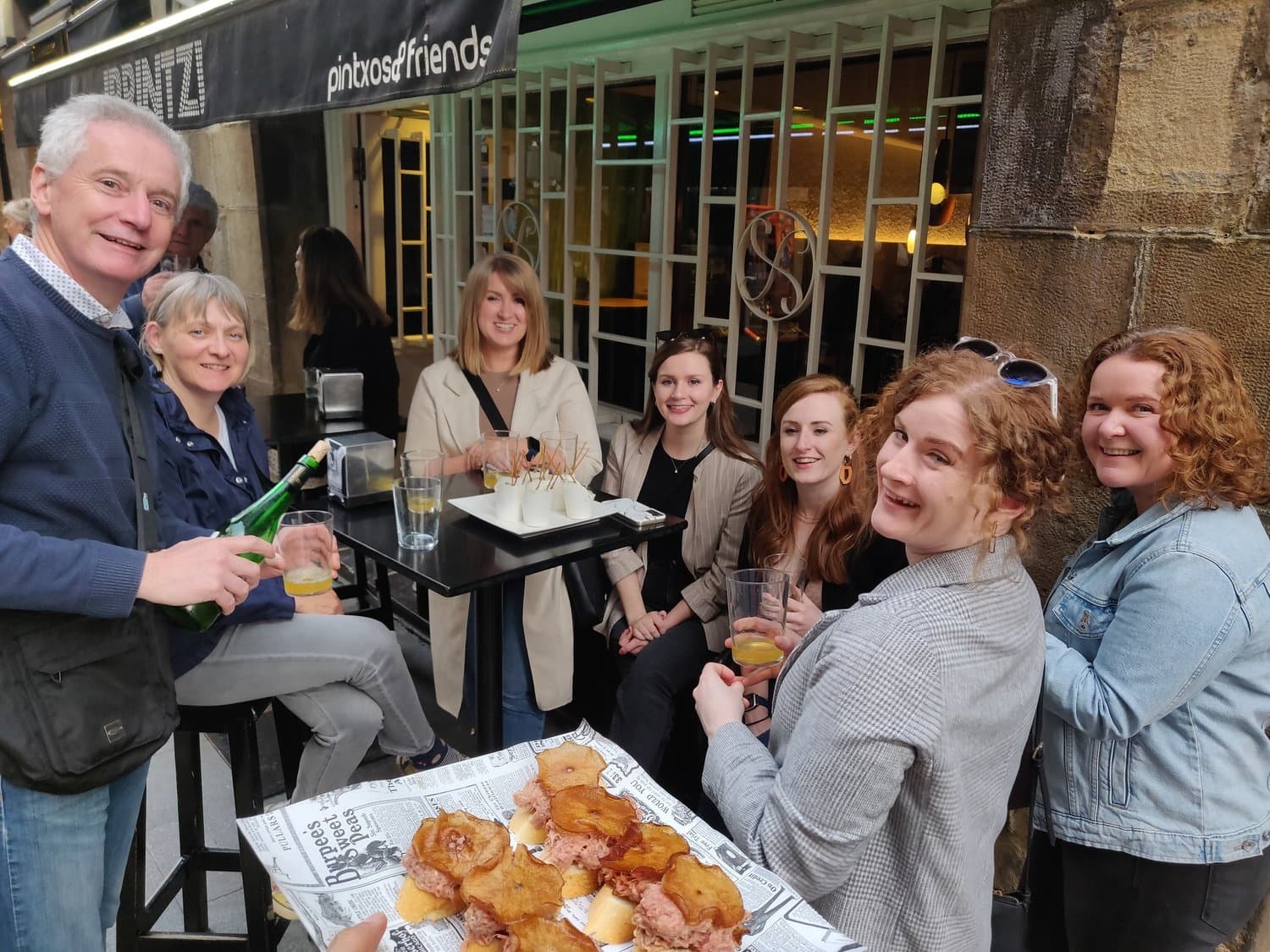 Outdoor pintxos tasting with group at a lively Bilbao street bar