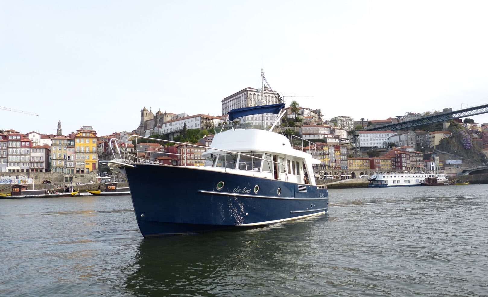 Blue motorboat approaching Porto riverside on Douro River