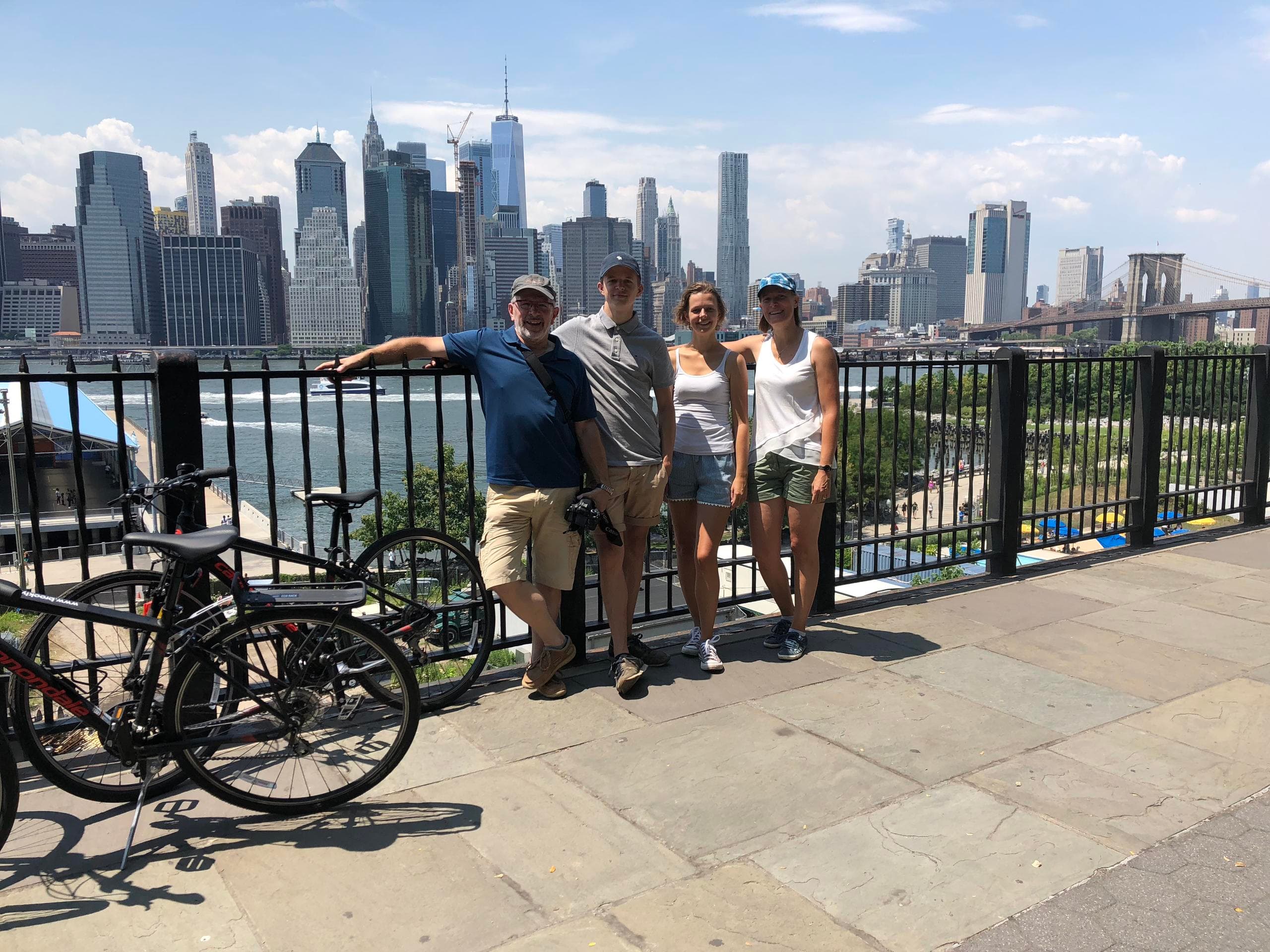 Friends with bikes along Brooklyn waterfront overlooking Manhattan